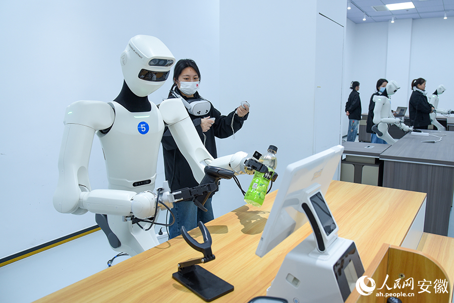 具身机器人正在训练师的操控下，练习扫描商品二维码。人民网记者 李希蒙摄