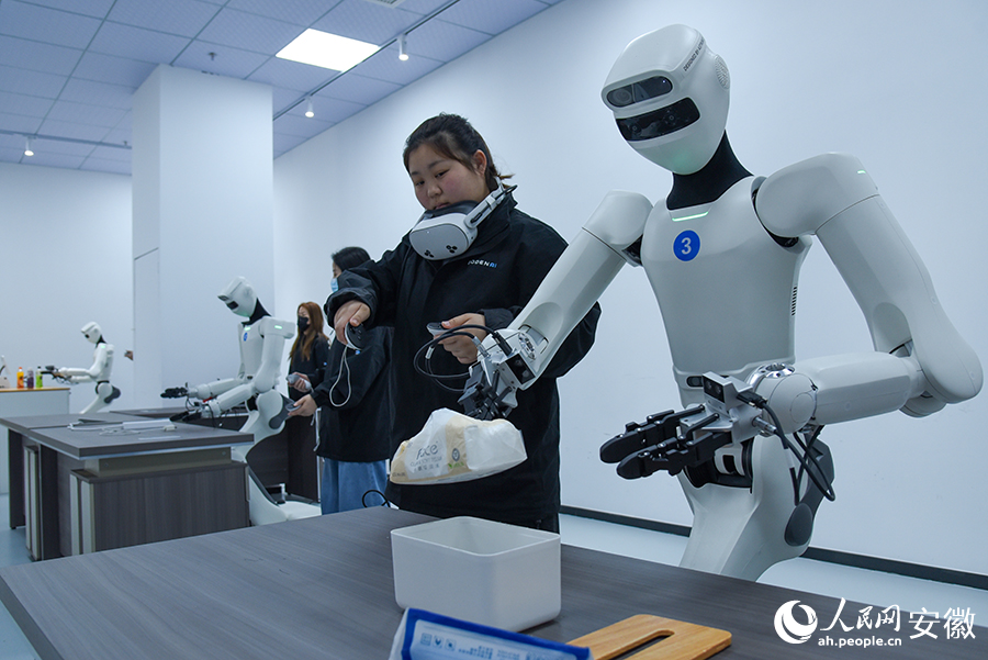 具身机器人正在训练师的操控下，反复训练动作。人民网记者 李希蒙摄